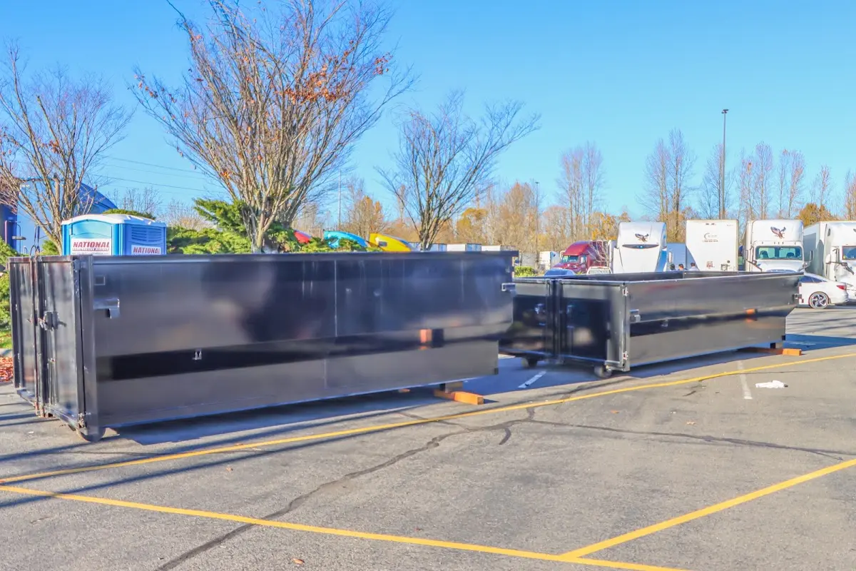 Professional dumpster rental service with roll-off container on residential driveway in Harris